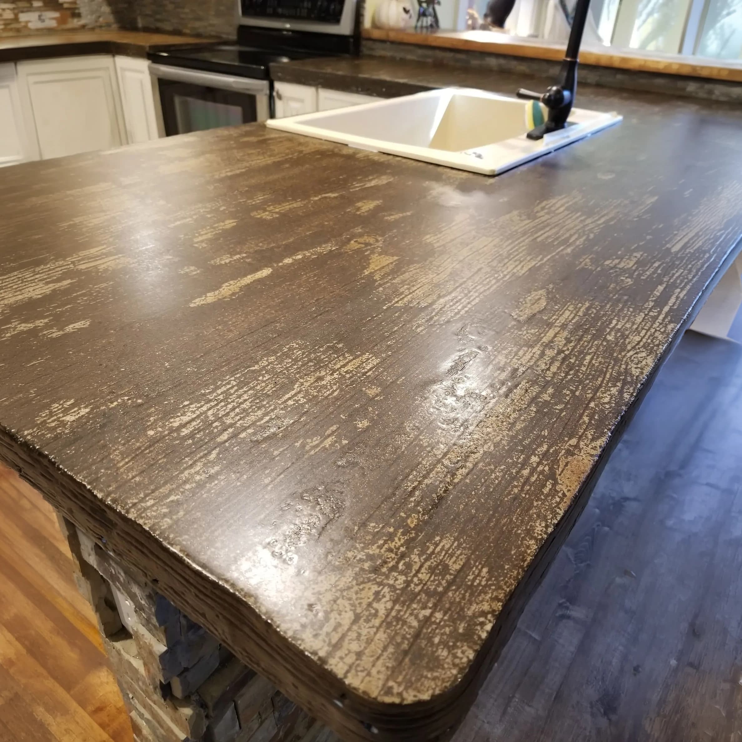 Custom concrete kitchen countertop finished with a realistic wood-grain texture and integrated sink in Lakeland, FL.